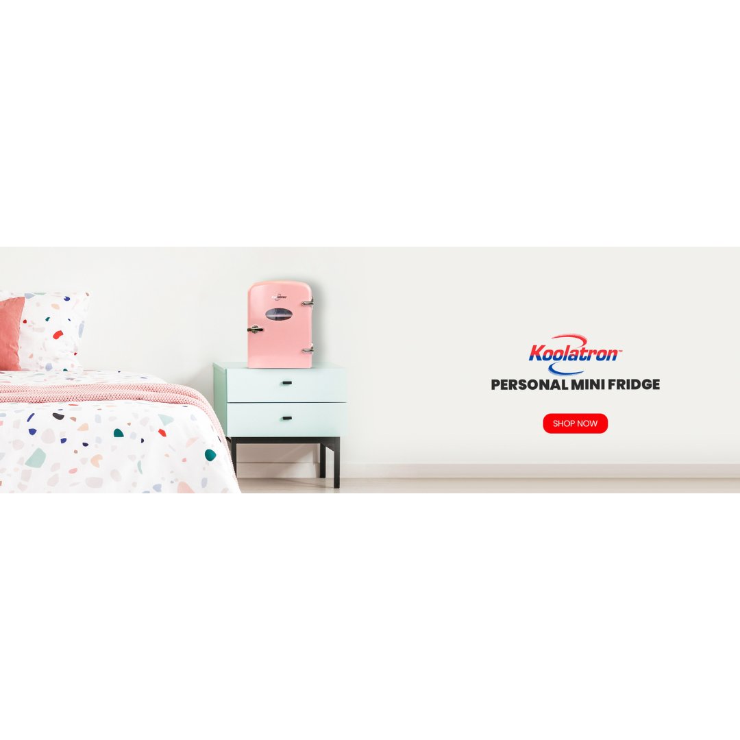 Lifestyle image of a light pink 4L mini fridge on a small white nightstand with a potted plant beside it