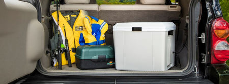 Lifestyle image of 27 qt thermoelectric cooler in the back of an SUV with fishing poles and lifejackets beside it