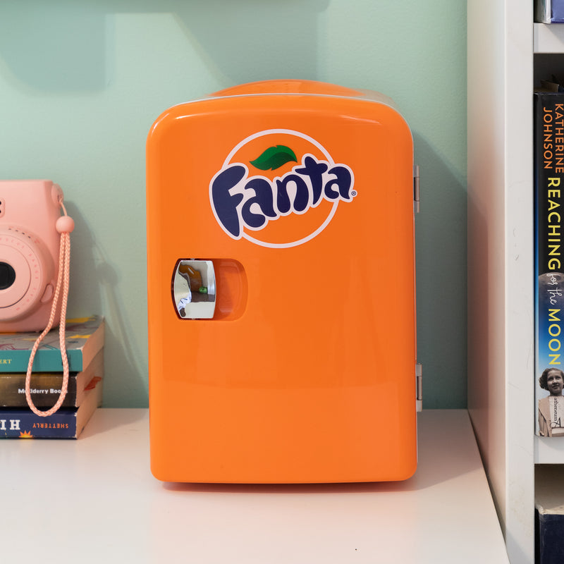 Product shot of Coca-Cola Fanta 6 can mini fridge open with 6 cans of Fanta inside on a white background