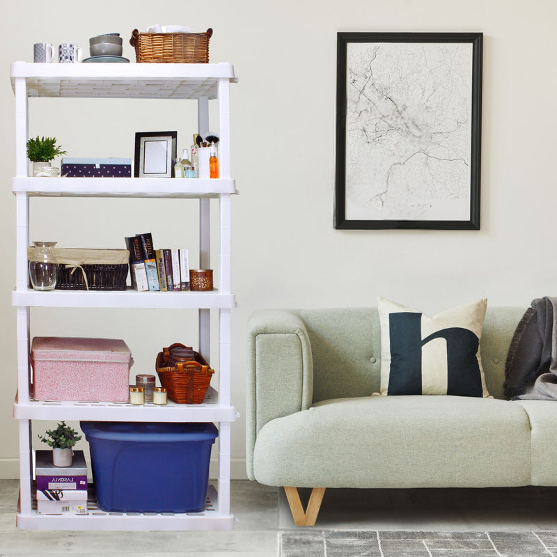 Oskar 5-tier storage shelves with small storage totes and various decor items set up in a living room beside a pale green sofa